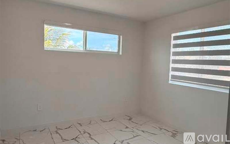 A room with a window and a tiled floor.