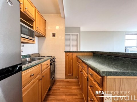 A kitchen with wooden cabinets and a granite countertop.