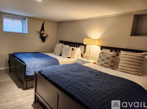 A bedroom with two beds and a lamp.