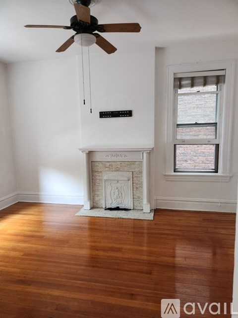A room with a fireplace and a ceiling fan.
