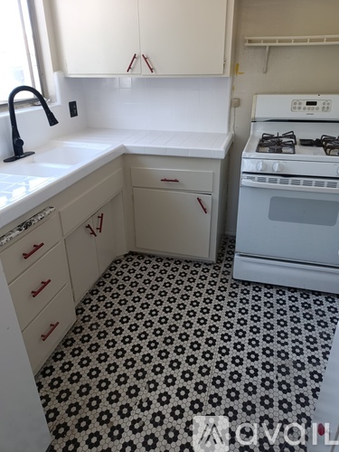 A kitchen with a black and white floor.