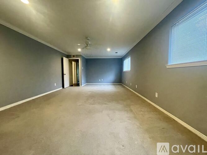 A spacious room with a door on the left and a window on the right.