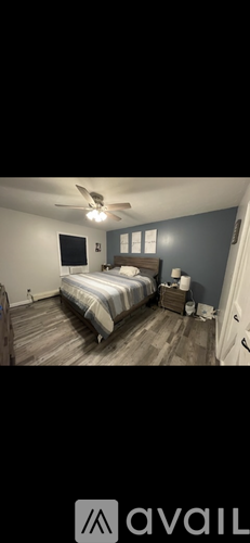 A bedroom with a bed, dresser, and ceiling fan.