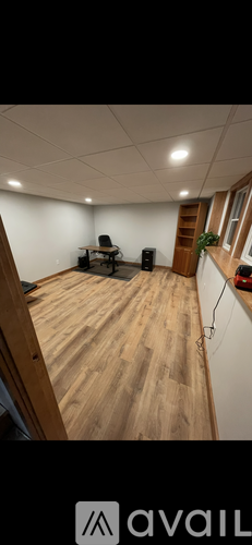 A room with wooden flooring and a white wall.