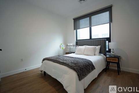 A bedroom with a large bed and a window.