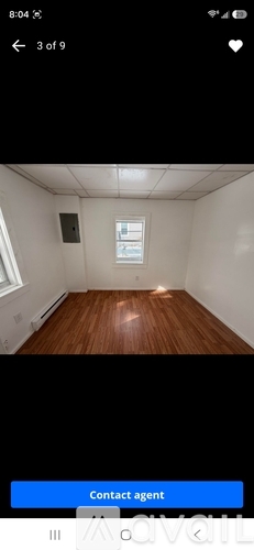 A room with wooden flooring and a window.