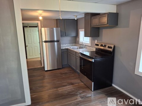 A kitchen with a refrigerator, oven, and microwave.