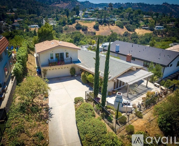 A house with a driveway and a fence in front of it.