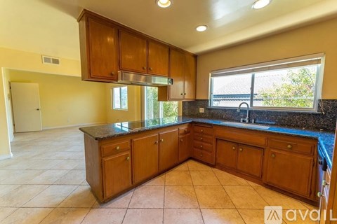 A kitchen with wooden cabinets and a black countertop.