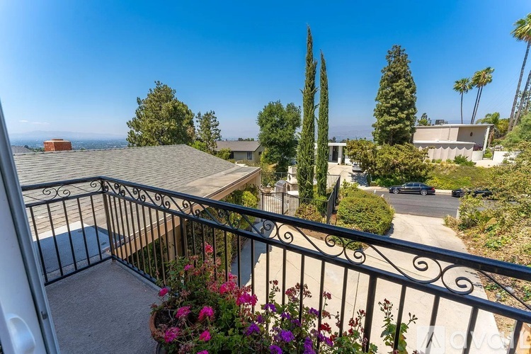 A balcony with a view of the ocean and a clear sky.