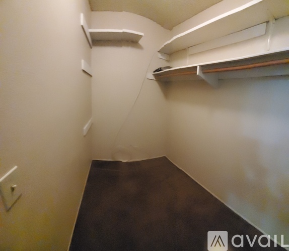 A room with a brown floor and white walls.