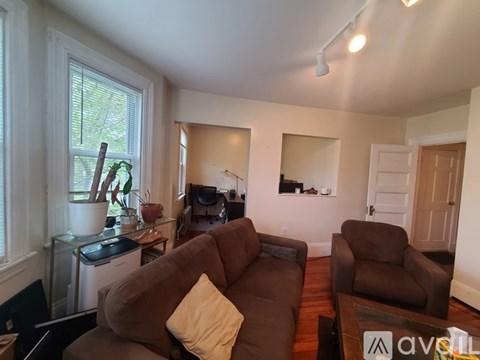 A living room with brown furniture and a large window.