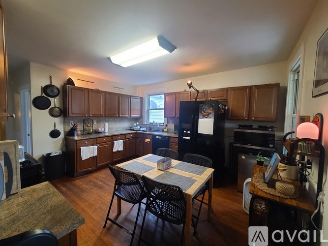 A kitchen with wooden cabinets and a black fridge.