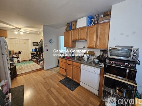 A kitchen with wooden cabinets and a white dishwasher.
