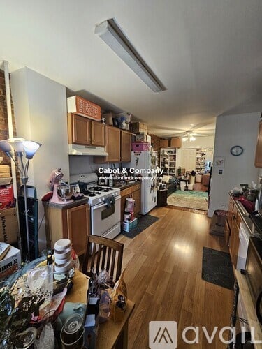 A kitchen with wooden floors and a variety of items on the counter.