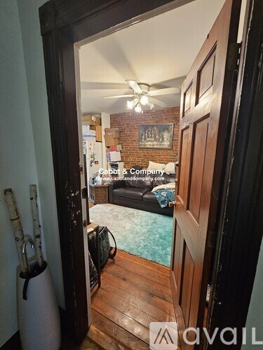 A room with a wooden floor and a brick wall.