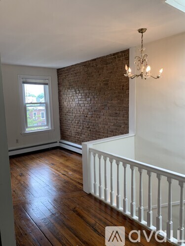 A room with a white railing and a chandelier.
