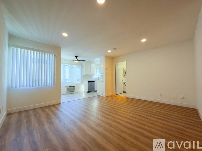A spacious room with wooden floors and white walls.