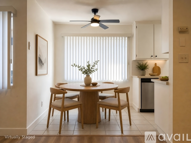 A dining room with a table and chairs.