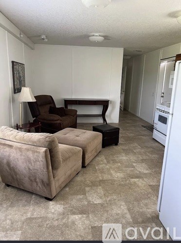 A living room with a brown chair and ottoman.