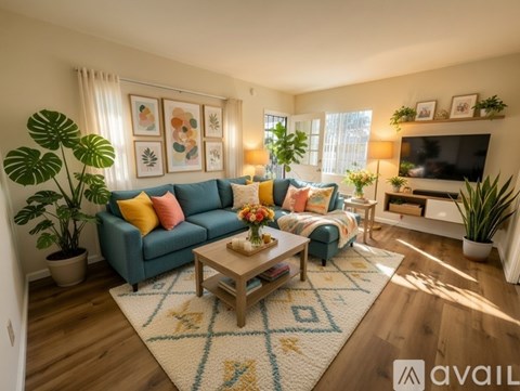 A living room with a blue couch, a coffee table, and a rug with a geometric pattern.