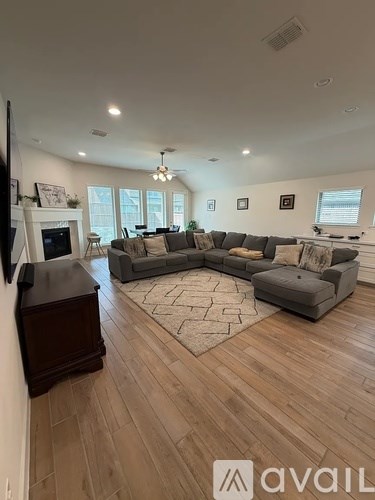 A living room with a grey sofa and a wooden floor.