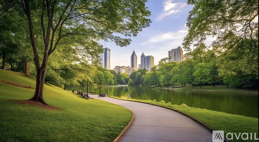 A park with a walking path, trees, and a lake with a city skyline in the background.