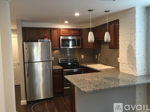 A kitchen with a granite countertop and stainless steel appliances.