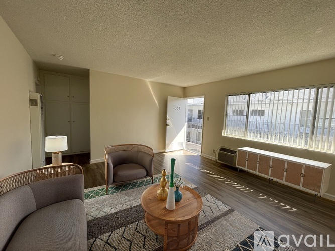A living room with a grey sofa, a wooden coffee table, and a lamp.
