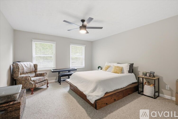 A bedroom with a bed, chair, and table.