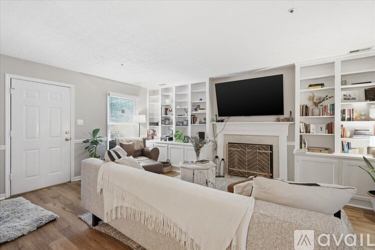 A living room with a white couch and a fireplace.