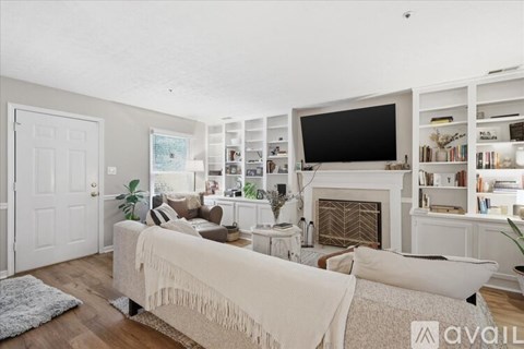A living room with a white couch and a fireplace.