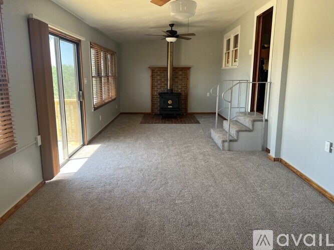A living room with a carpeted floor and a fireplace.