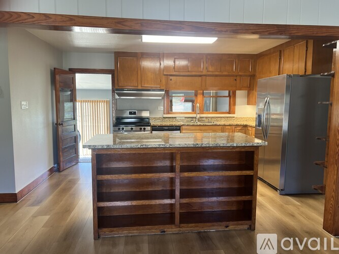A kitchen with wooden cabinets and a marble countertop.