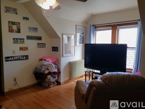 A living room with a brown leather couch and a flat screen TV.