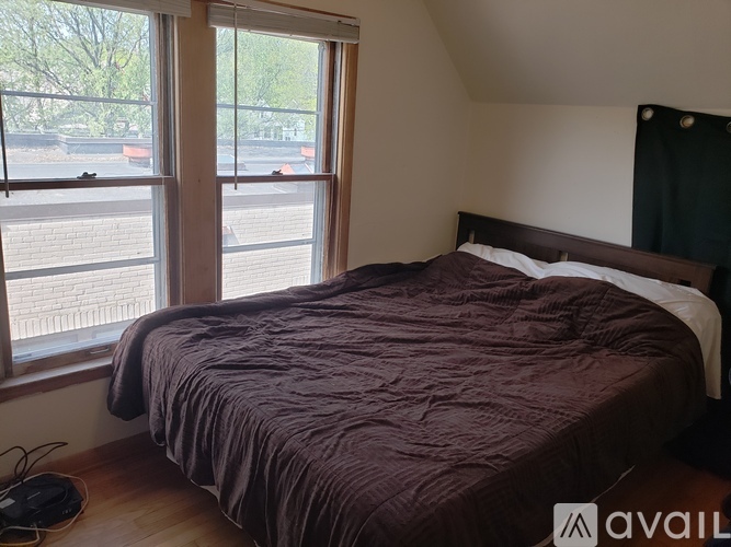 A bedroom with a bed and a window overlooking a parking lot.