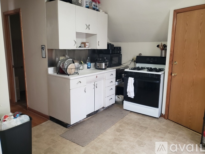 A kitchen with white cabinets and a black stove top.