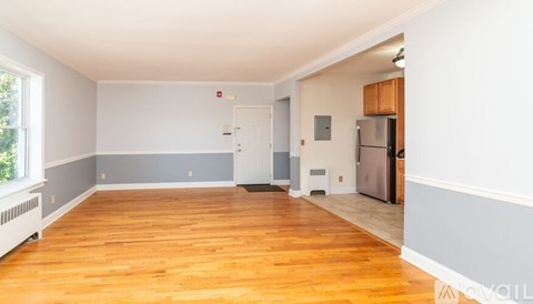A spacious room with wooden floors and white walls.