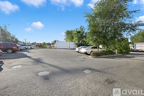 A parking lot with a few cars and trees.