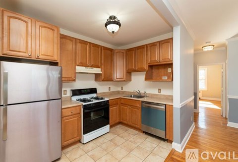 A kitchen with wooden cabinets and a refrigerator.