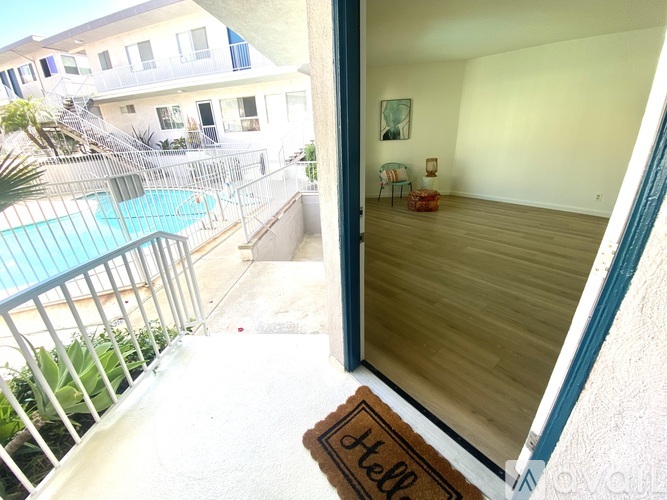 A balcony with a pool and a doorway leading to a room.