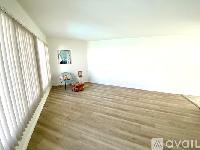 A room with wooden flooring and a chair with a blue cushion.