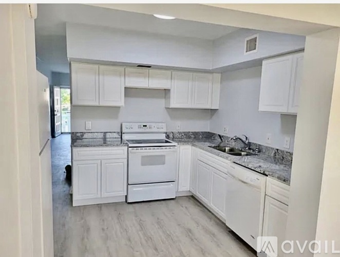 A kitchen with white appliances and cabinets.