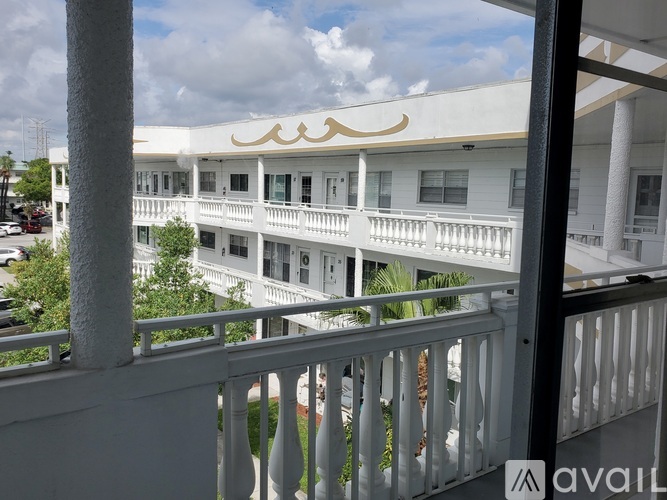 A white building with a balcony and a logo on the top.