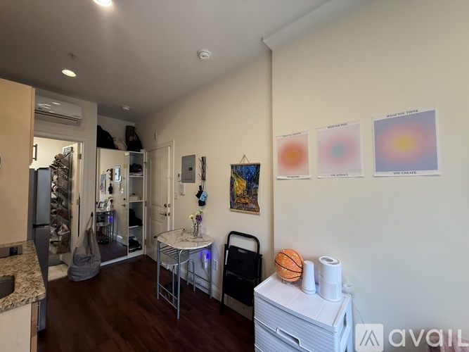 A living room with a dining table, chairs, and pictures on the wall.