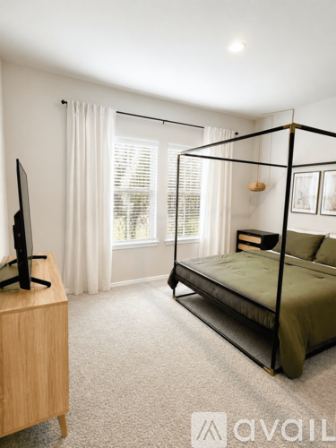 A bedroom with a four poster bed and a television.