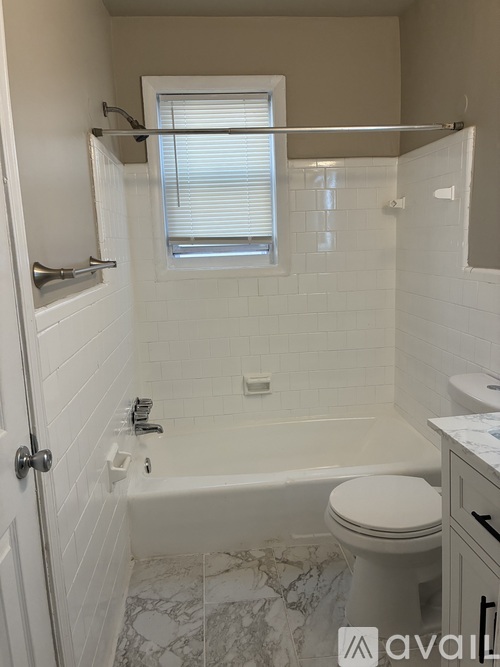 A bathroom with a toilet, tub, and sink.