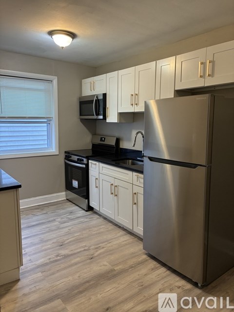 A kitchen with a stainless steel refrigerator, microwave, and oven.