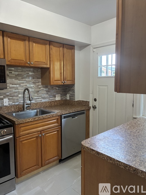 A kitchen with wooden cabinets and granite countertops.
