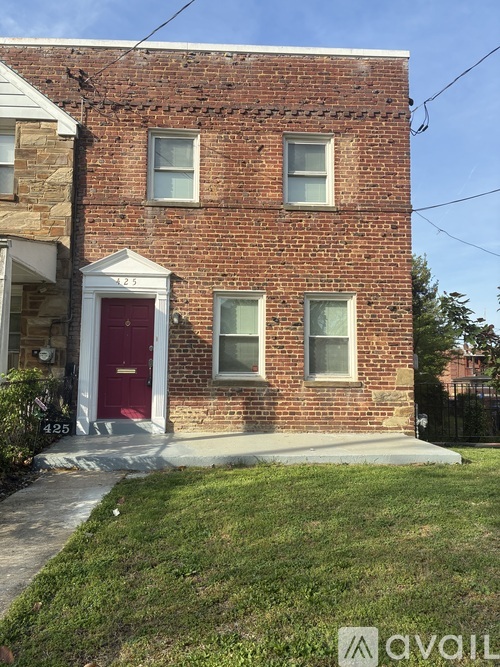 A red brick house with a white door and windows.